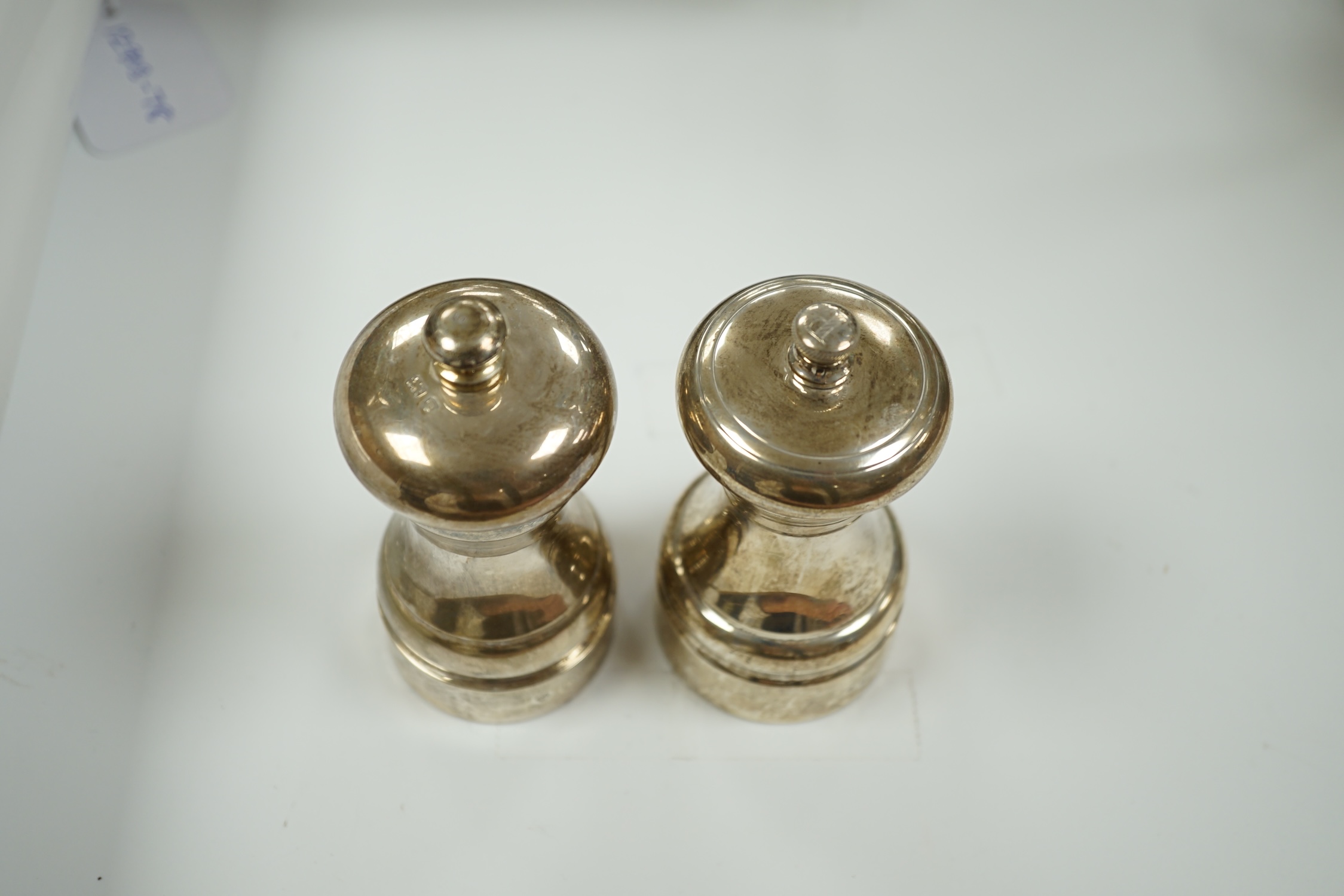 Two modern silver mounted pepper grinders, tallest 10.2cm.